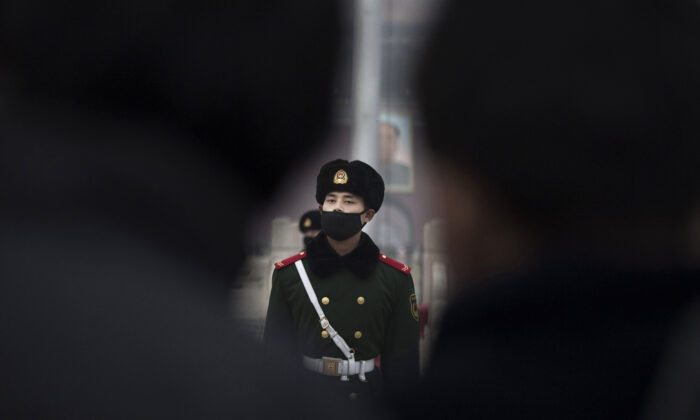 A Chinese paramilitary police officer wears a mask to protect against pollution, a rare occurrence, as they march during smog in Tiananmen Square in Beijing on Dec. 9, 2015. (Kevin Frayer/Getty Images)