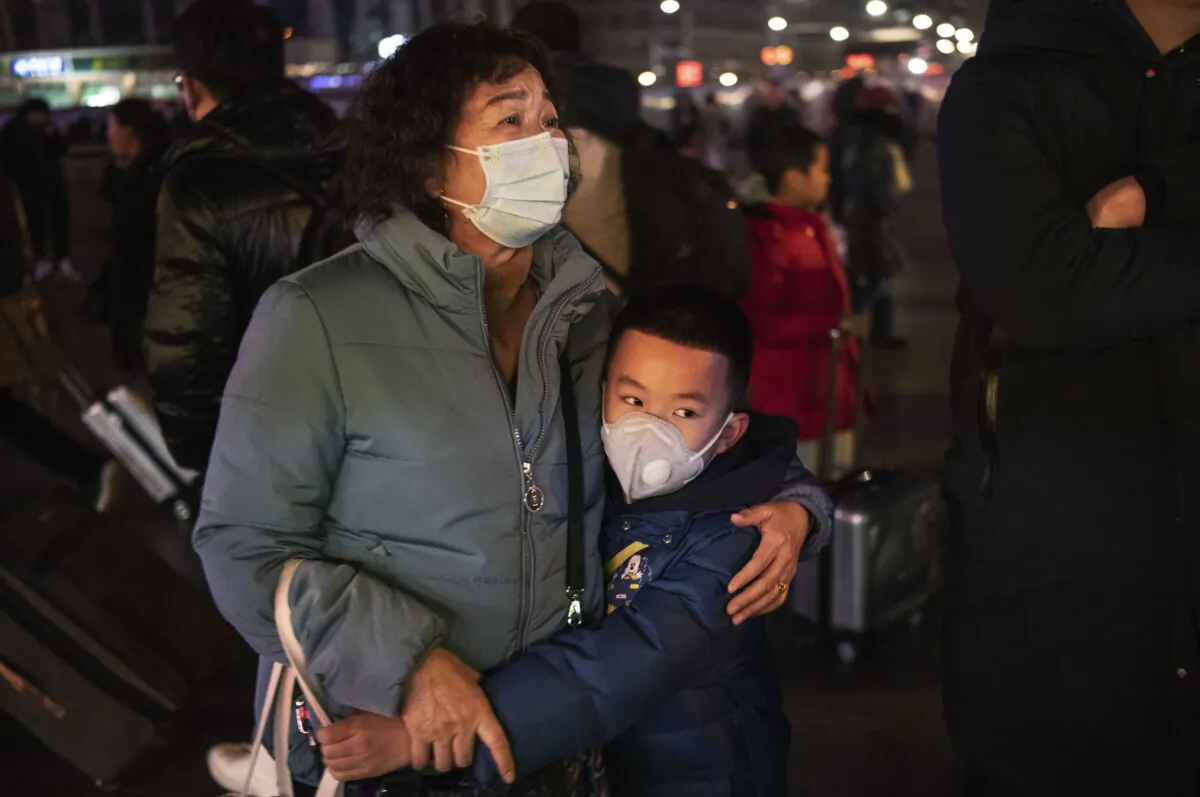 A Chinese boy hugs a relative as she leaves to board a train at Beijing Railway station in Beijing, China on Jan. 21, 2020. (Kevin Frayer/Getty Images)