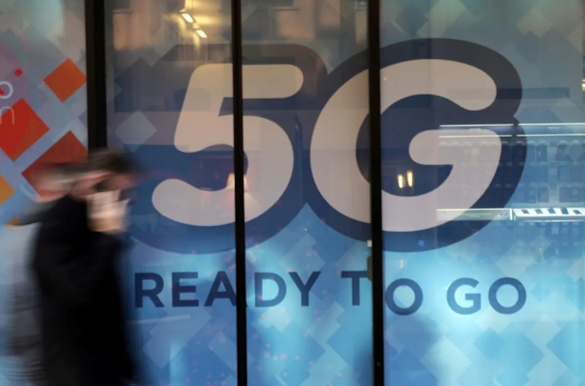 A man walks past a 5G sign in Monaco, on Nov. 28, 2019. (Eric Gaillard/Reuters)