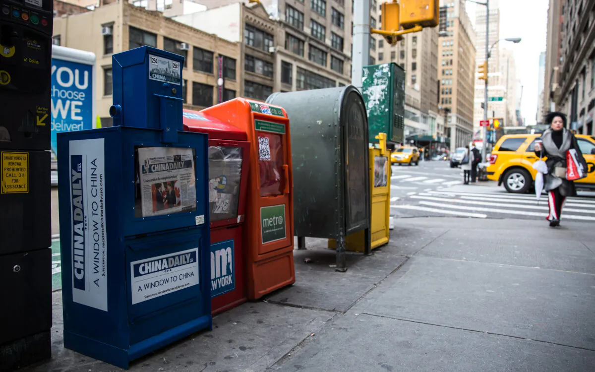 A paid China Daily newspaper box is with other free daily papers in Midtown Manhattan on Dec. 6, 2017. (Benjamin Chasteen/The Epoch Times)