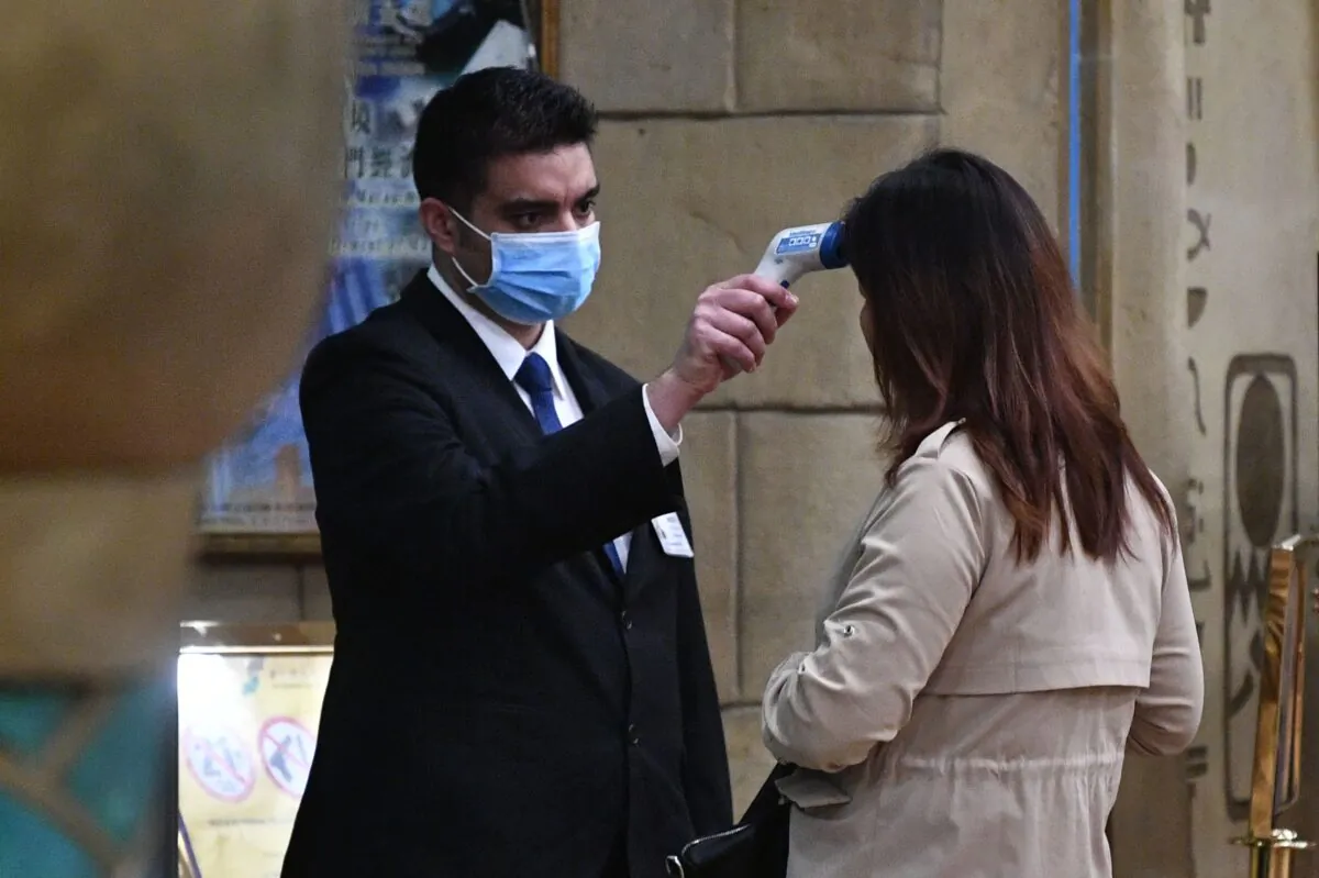 A staff member checks the temperature of a guest entering the casino of the New Orient Landmark hotel in Macau after the former Portuguese colony reported its first case of the new SARS-like virus that originated from Wuhan in China, on Jan. 22, 2020. (Anthony Wallace/AFP via Getty Images)