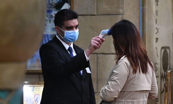 A staff member checks the temperature of a guest entering the casino of the New Orient Landmark hotel in Macau after the former Portuguese colony reported its first case of the new SARS-like virus that originated from Wuhan in China, on Jan. 22, 2020. (Anthony Wallace/AFP via Getty Images)