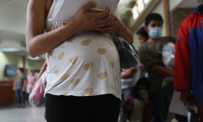 A pregnant Honduran migrant stands in line with other migrants for a bus to another place inside the United States, in McAllen, Texas, on Aug. 15, 2016. (John Moore/Getty Images)