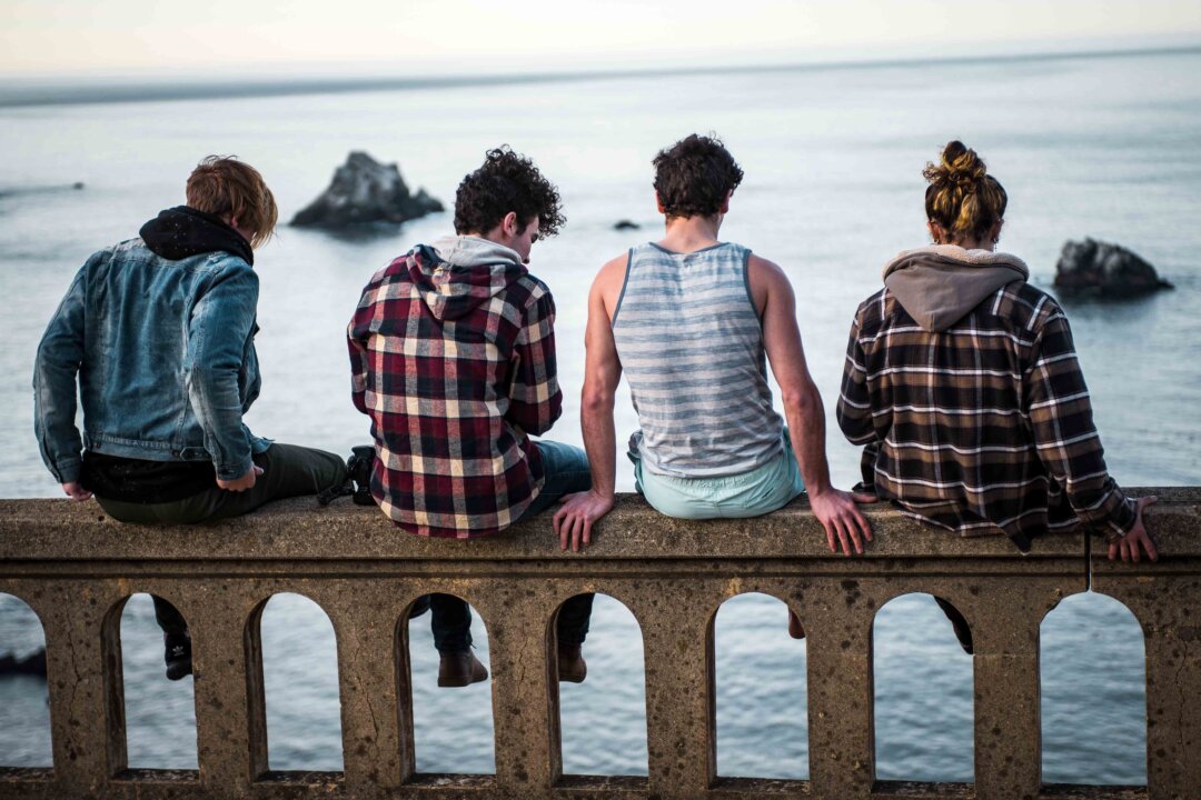 Teens sit at the edge of Bixby Creek Bridge in Monterey, United States. (Sammie Vasquez/Unsplash