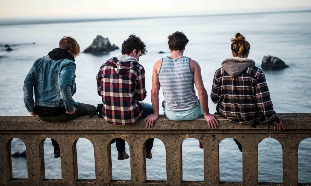 Teens sit at the edge of Bixby Creek Bridge in Monterey, United States. (Sammie Vasquez/Unsplash)