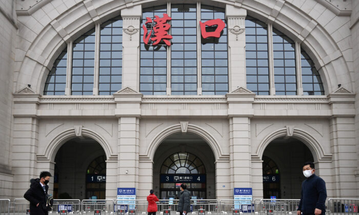 People walk past the closed Hankou Railway Station after the city was locked down following the outbreak of a new coronavirus in Wuhan, Hubei province, China on Jan. 23, 2020. (China Daily via Reuters)