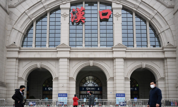 People walk past the closed Hankou Railway Station after the city was locked down following the outbreak of a new coronavirus in Wuhan, Hubei province, China, on Jan. 23, 2020. (China Daily via Reuters)