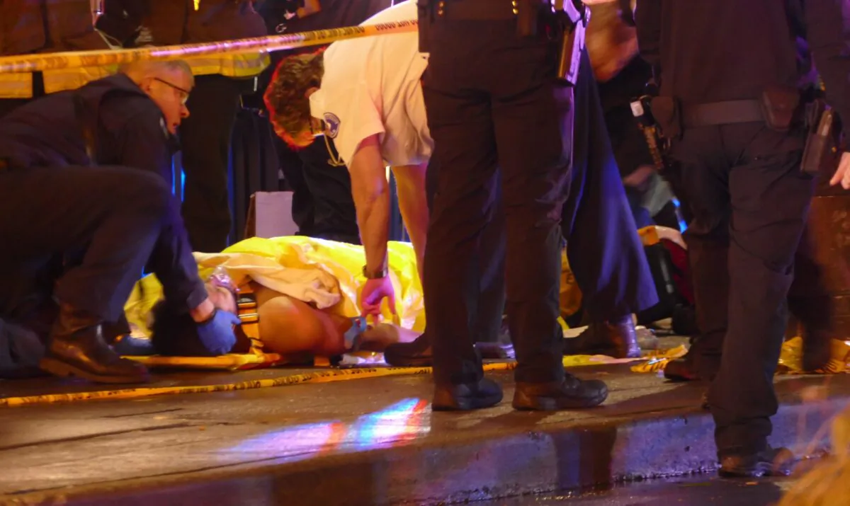 Officers attend to one of several shooting victims on Jan. 22, 2020, in Seattle, after a gunman opened fire in the heavily trafficked downtown area. (David Silver via AP)