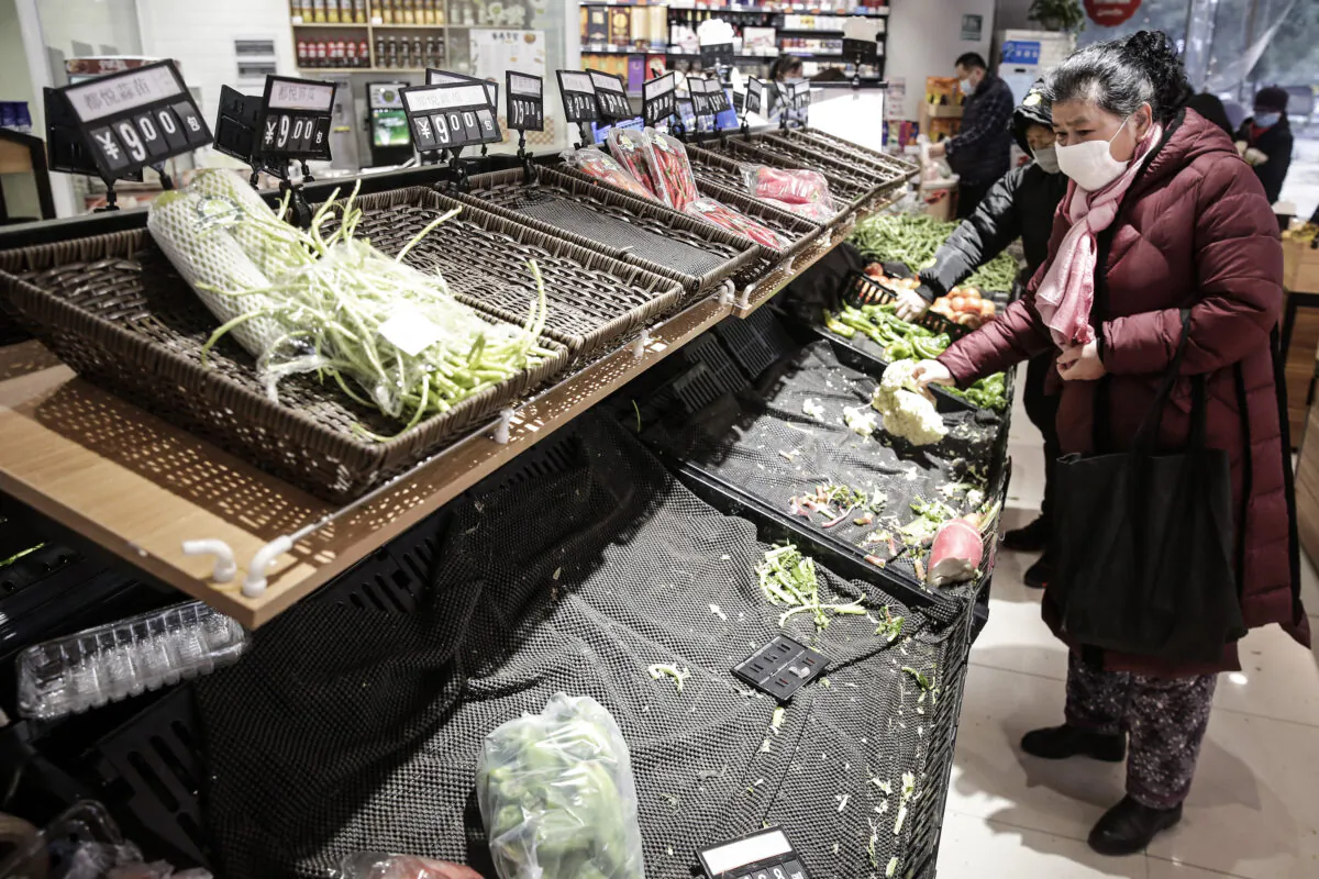 A resident wears a mask to buy vegetables in the market in Wuhan, Hubei Province, China, on Jan. 23, 2020. Flights, trains, and public transport including buses, subway, and ferry services have been temporarily closed and officials have told residents to stay in town in order to help stop the outbreak of a strain of coronavirus that has killed 18 people and infected over 600 in places as far away as the United States. This week marks the start of Chinese Lunar New Year holiday, the busiest season for Chinese travelers.  (Getty Images)