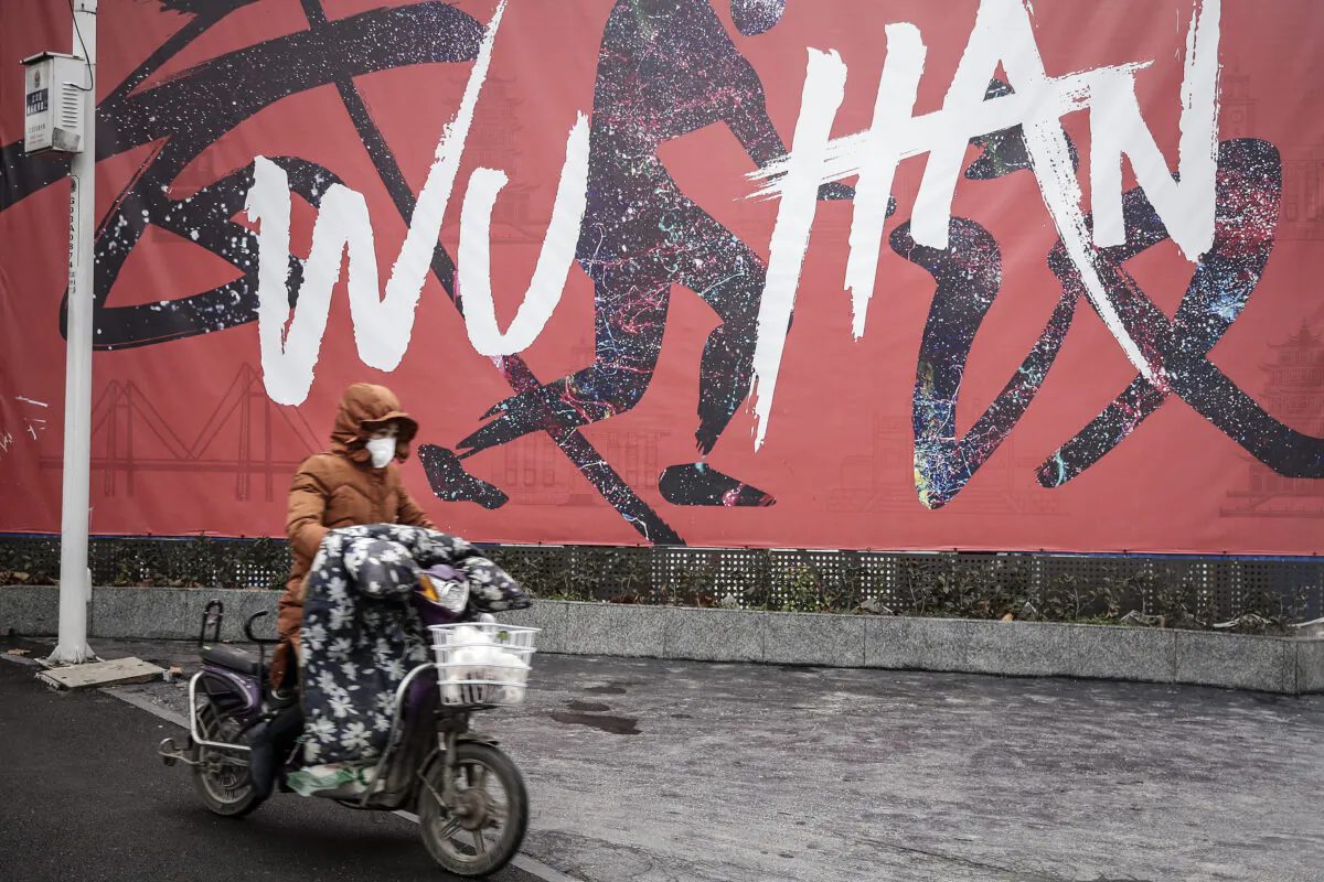 A woman wears a mask while riding an electric bicycle in Wuhan, Hubei Province, China, on Jan. 22, 2020. (Getty Images)
