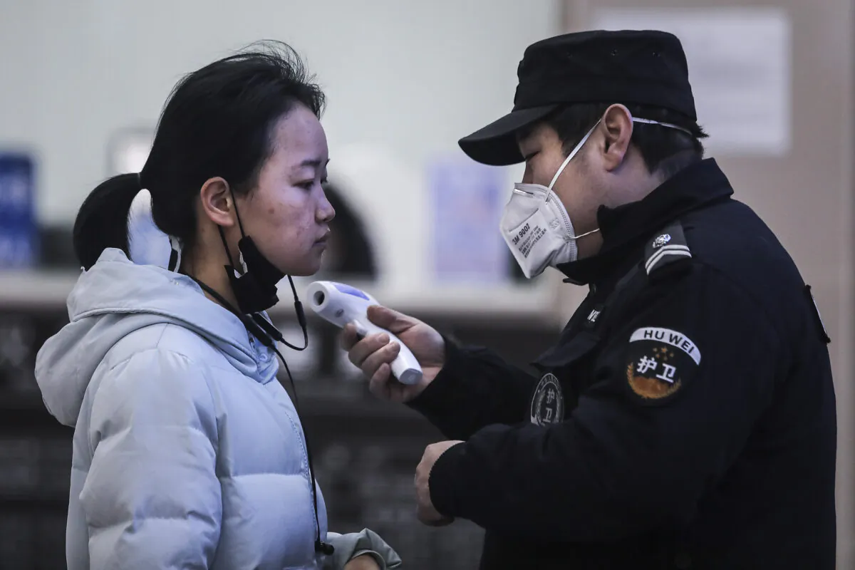 Security personnel check the temperature of passengers in the Wharf at the Yangtze River in Wuhan, Hubei Province, China, on Jan. 22, 2020. (Getty Images)