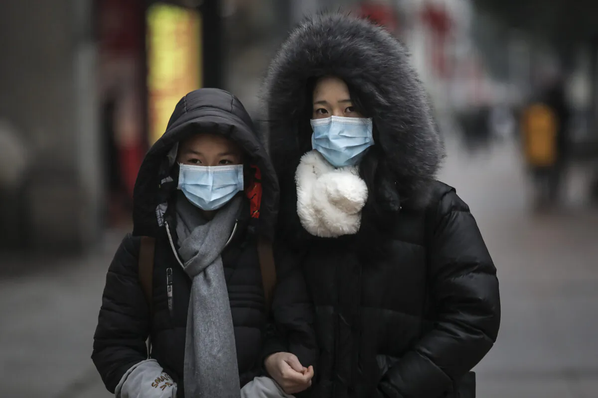 A family wears masks while walking in the street in Wuhan, Hubei province, China, on Jan. 22, 2020. (Getty Images)