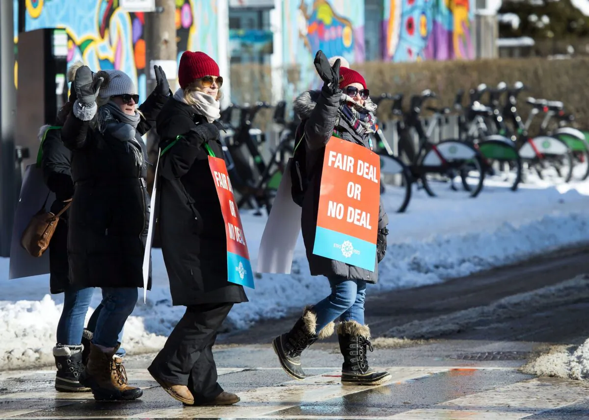 Teachers of the Elementary Teachers' Federation of Ontario wave to passing cars as they participate in a full withdrawal-of-services strike in Toronto on Jan. 20, 2020. (The Canadian Press/Nathan Denette)