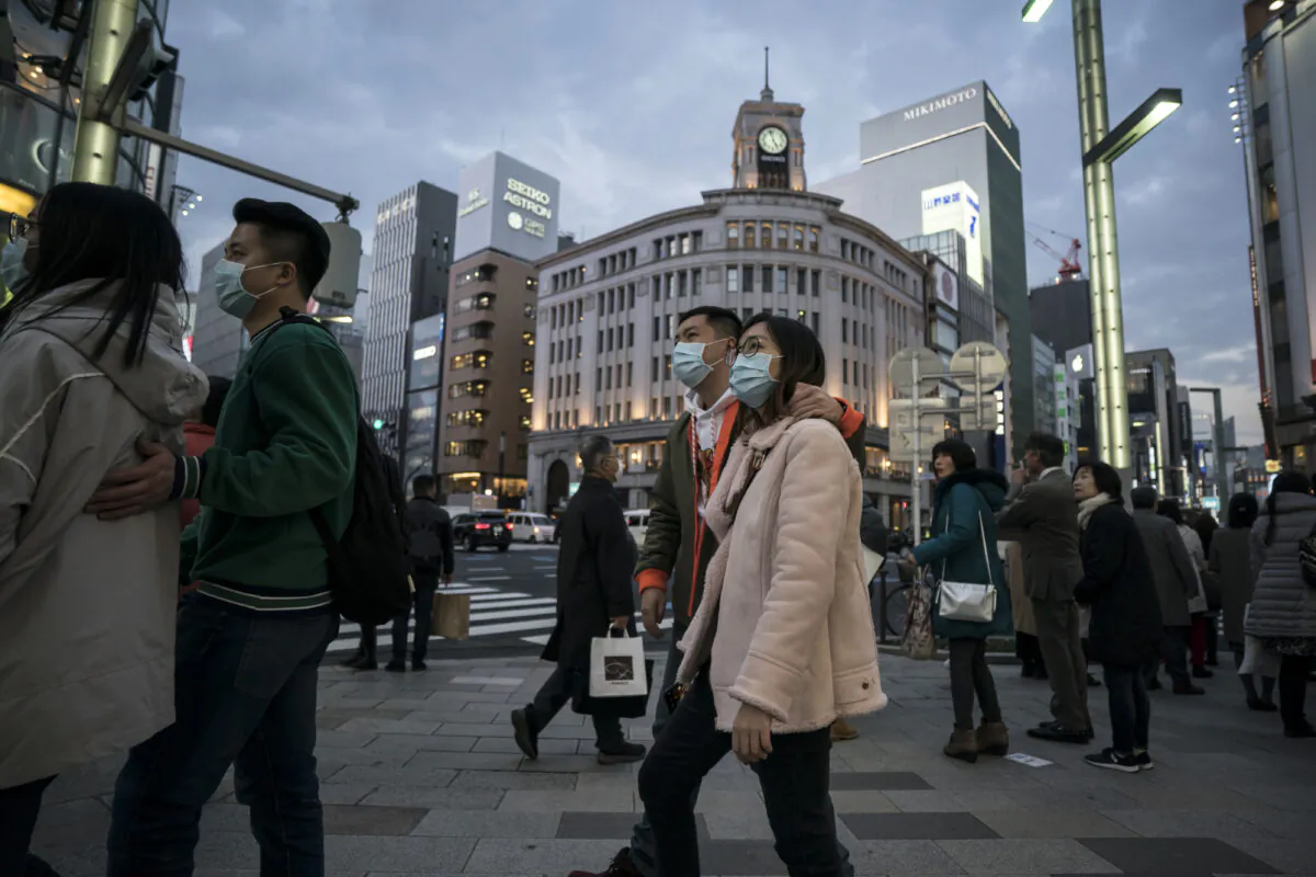 Chinese tourists wearing masks walk through the Ginza shopping district in Tokyo, Japan on Jan. 24, 2020. (Tomohiro Ohsumi/Getty Images)