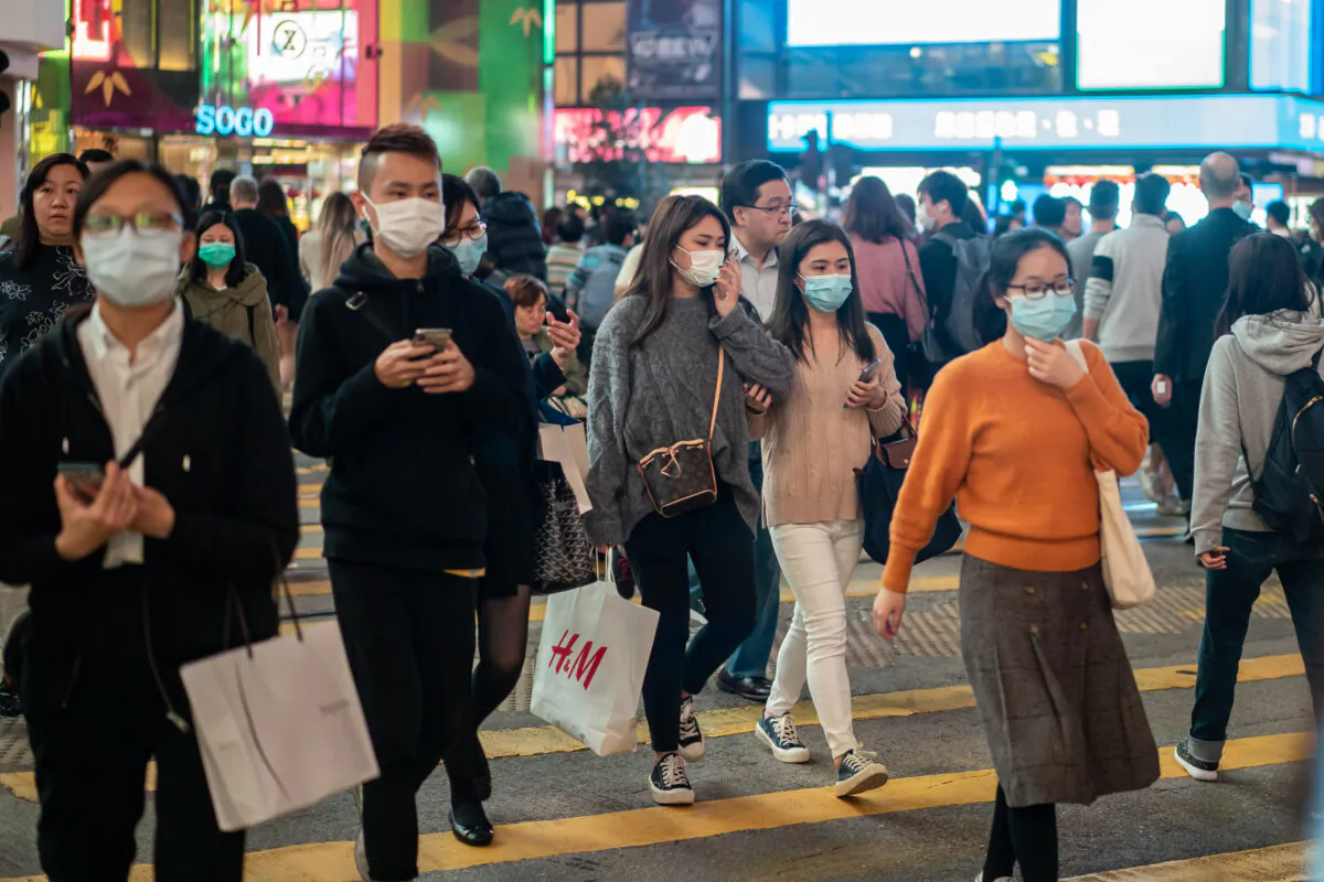 Pedestrians wear face masks as they walk through a crosswalk in Causeway Bay district in Hong Kong on Jan. 23, 2020. (Anthony Kwan/Getty Images)