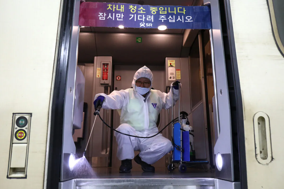 A worker wearing protective gear sprays anti-septic solution in a train amid concerns over the spread of the 2019 Novel Coronavirus, also known as the Wuhan coronavirus, in Seoul, South Korea on Jan. 24, 2020. (Chung Sung-Jun/Getty Images)