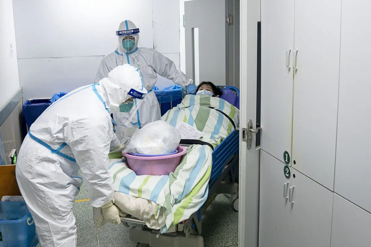 Medical workers transfer a patient out of the intensive care unit at Zhongnan Hospital of Wuhan University in Wuhan in central China's Hubei Province. on Jan. 24, 2020. (Zong Qi/Xinhua via AP)