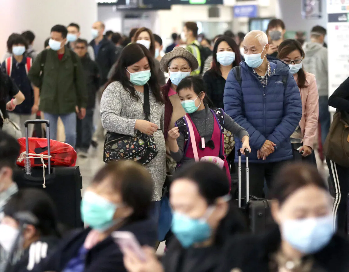 Passengers wearing protective face masks enter the departure hall of a high speed train station in Hong Kong on Jan. 24, 2020. (Achmad Ibrahim/AP Photo)