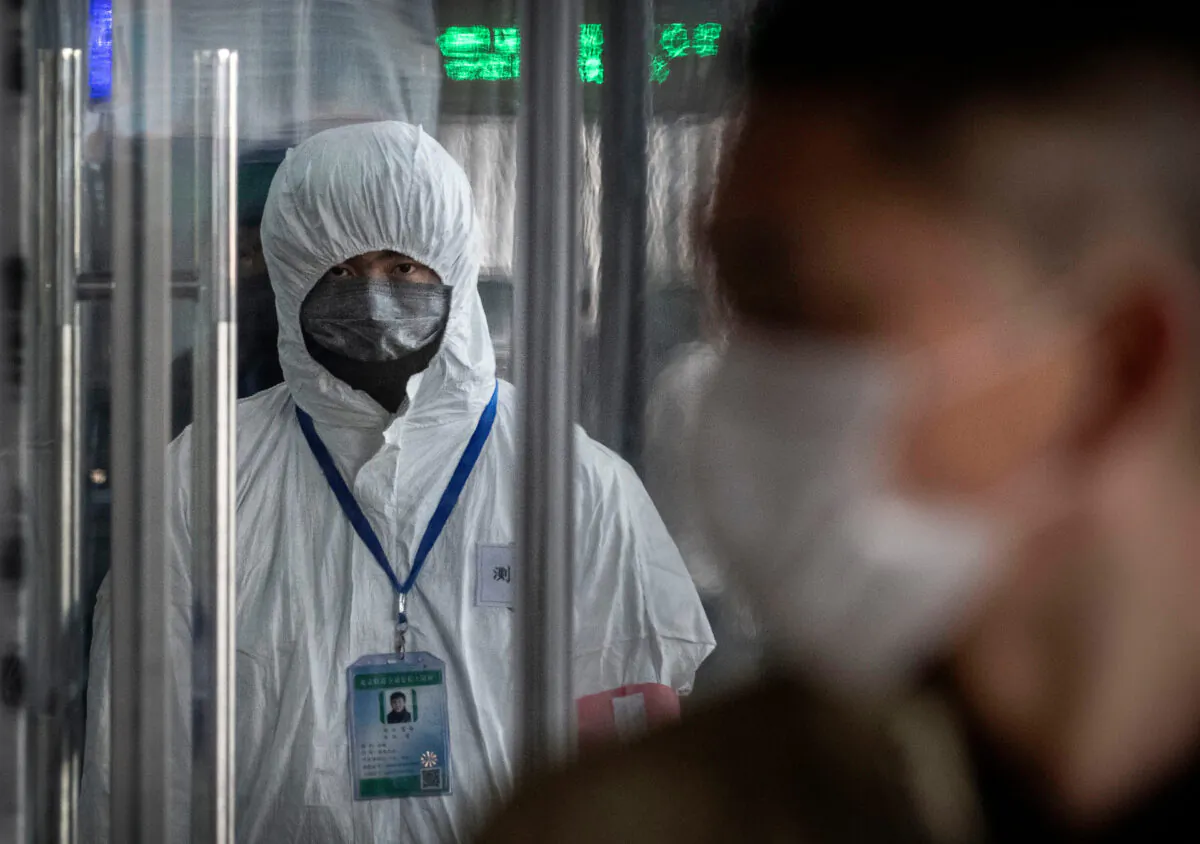  A Chinese health worker waits to check the temperature of travellers entering a train station during the Chinese New Year and Spring Festival in Beijing, China, on Jan. 25, 2020. (Kevin Frayer/Getty Images)