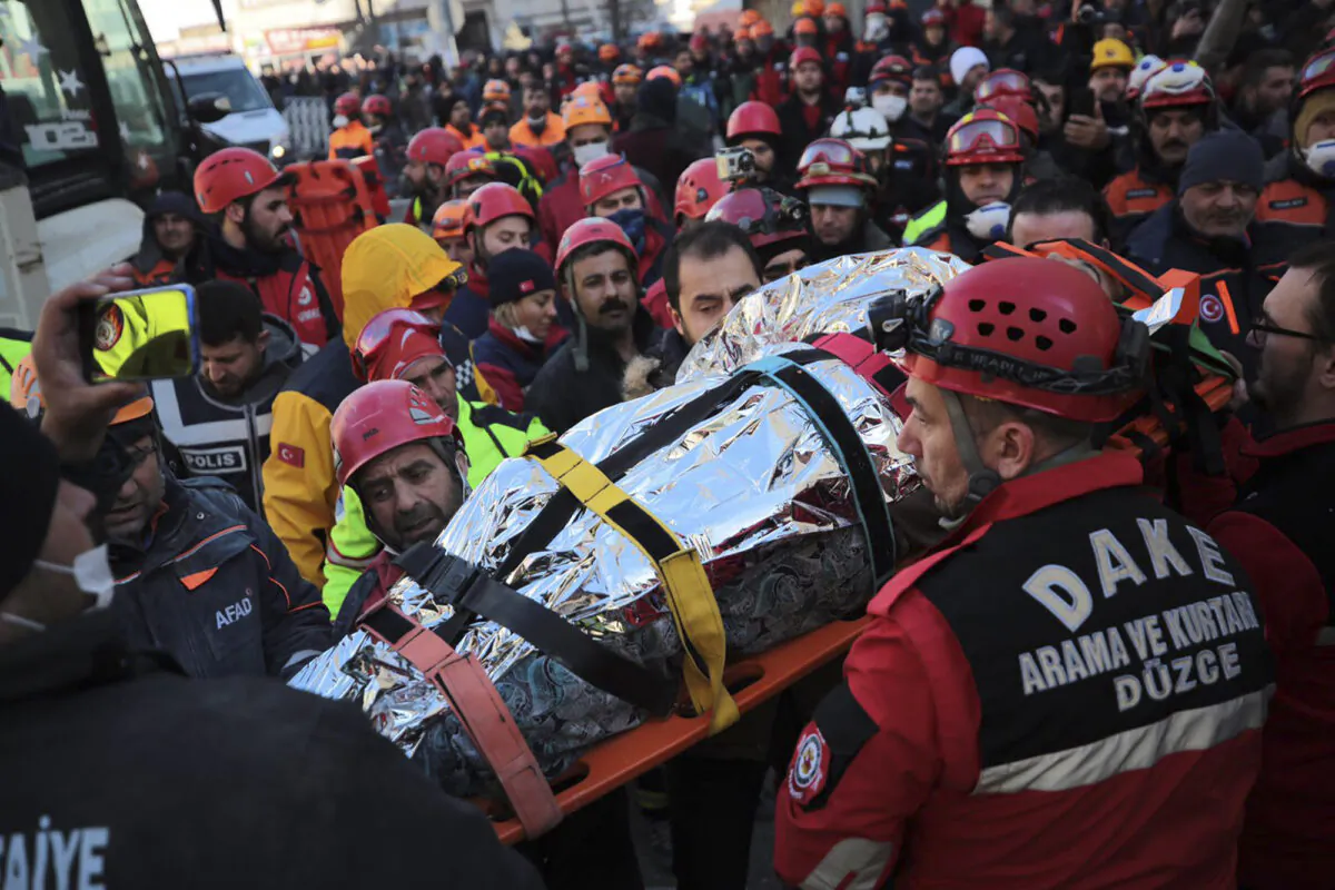 Members of rescue services carry a wounded man, that was found in the rubble of a building destroyed by earthquake, in Elazig, eastern Turkey, on Jan. 25, 2020. (IHH/ Humanitarian Relief Foundation via AP)