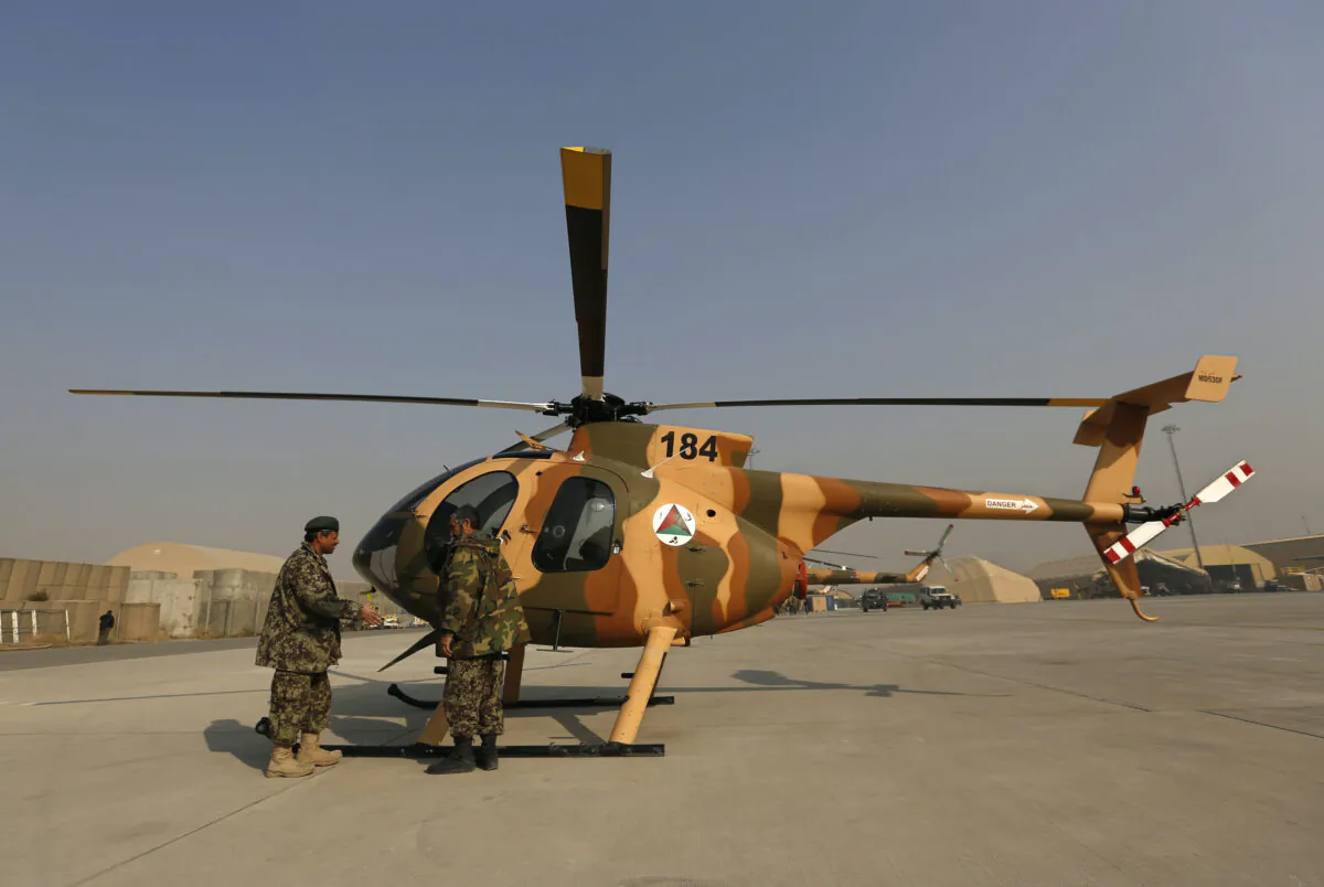 Members of the Afghan Air Force crew stand next to a helicopter at the military airport in Kabul on Dec. 18, 2014. (Mohammad Ismail/Reuters-File)