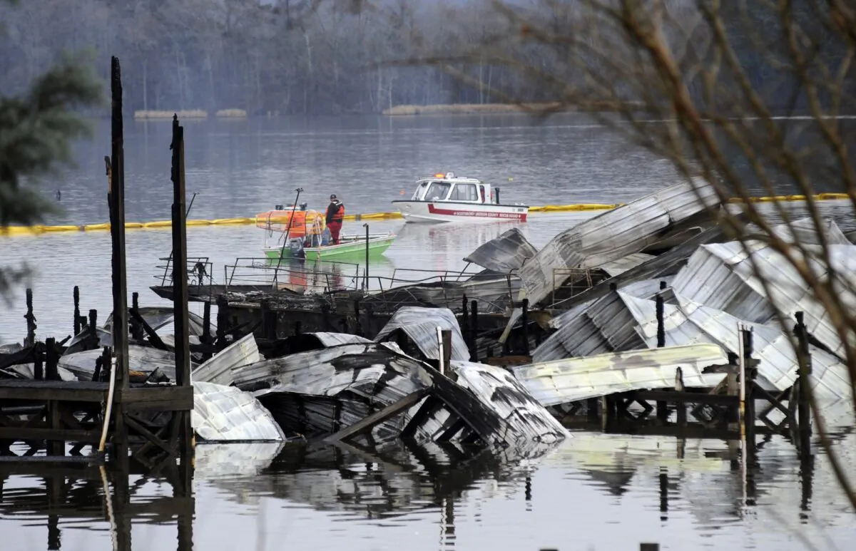 People on boats patrol near the charred remains of a dock following a fatal fire at a Tennessee River marina in Scottsboro, Ala., on Jan. 27, 2020. (Jay Reeves/AP Photo)