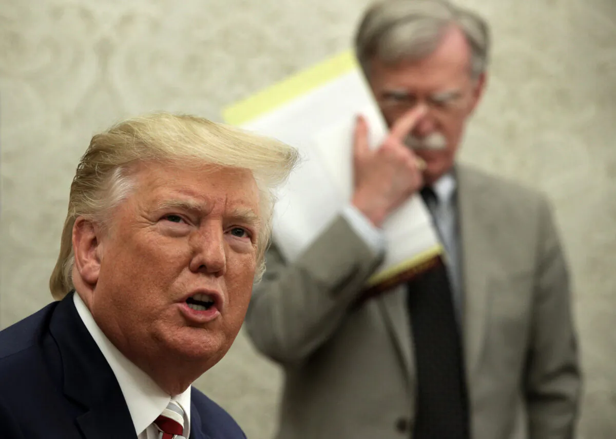 President Donald Trump speaks to members of the media as National Security Adviser John Bolton listens in the Oval Office of the White House on Aug. 20, 2019. (Alex Wong/Getty Images)