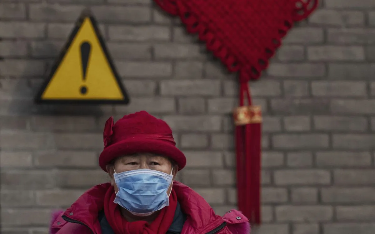 A Chinese visitor wears a protective mask as she was touring the grounds of the Temple of Heaven, which remained open during the Chinese New Year holiday in Beijing, on Jan. 27, 2020. (Kevin Frayer/Getty Images)