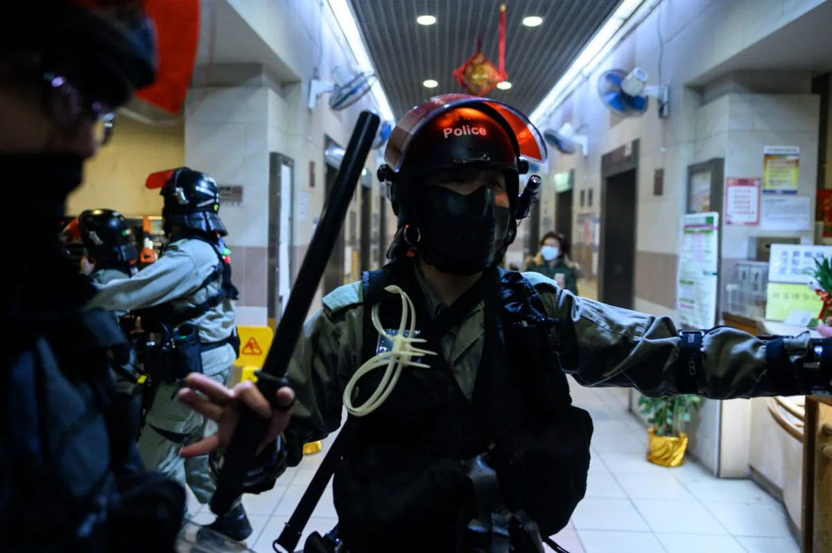 Riot police stand at the entrance of a residential building as residents protest against plans for an empty local housing estate to become a temporary quarantine camp for patients and frontline medical staff of a SARS-like virus outbreak which began in the Chinese city of Wuhan, in the Fanling district in Hong Kong on Jan. 26, 2020. (PHILIP FONG/AFP via Getty Images)