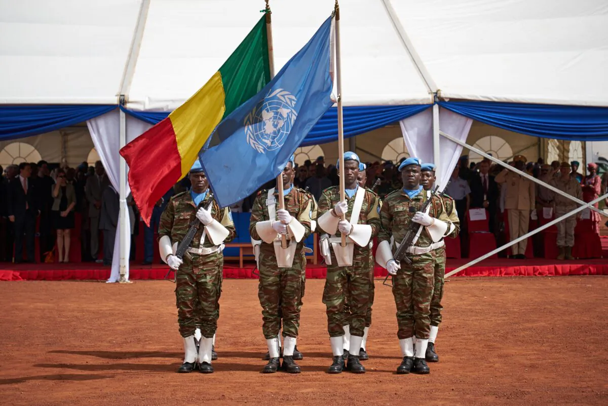 Soldiers hold the UN and Malian flags during the ceremony of Peacekeepers' Day at the operating base of MINUSMA in Bamako, Mali, on May 29, 2018. (Michele Cattani/AFP via Getty Images)