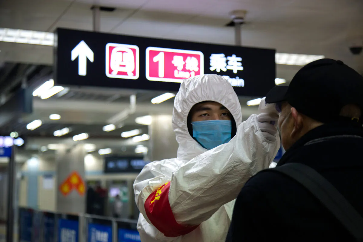 A health worker checks the temperature of a man entering the subway in Beijing, China on Jan. 26, 2020. (Betsy Joles/Getty Images)