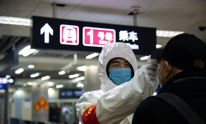 A health worker checks the temperature of a man entering the subway in Beijing, China on Jan. 26, 2020. (Betsy Joles/Getty Images)