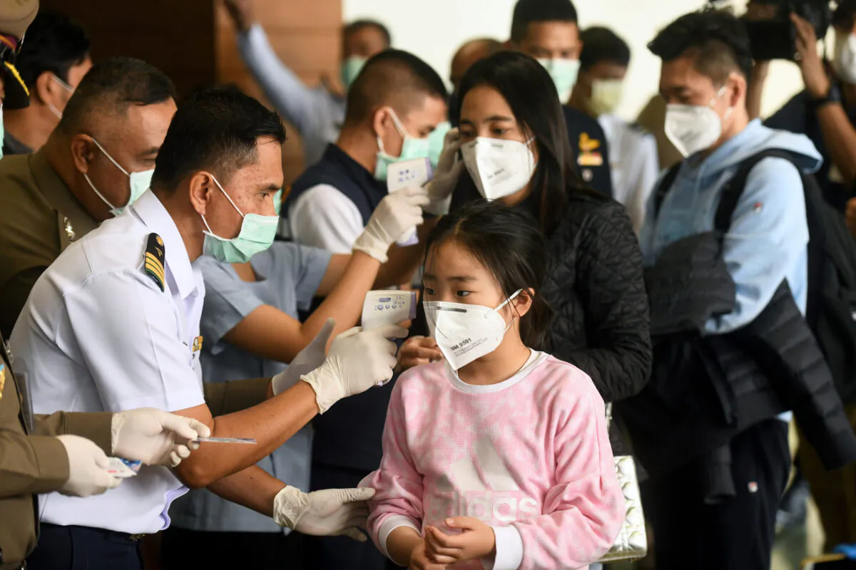 Tourists who arrive at Bangkok's Don Mueang Airport in Thailand have their temperatures checked on Jan. 25, 2020. (Panumas Sanguanwong/Reuters)