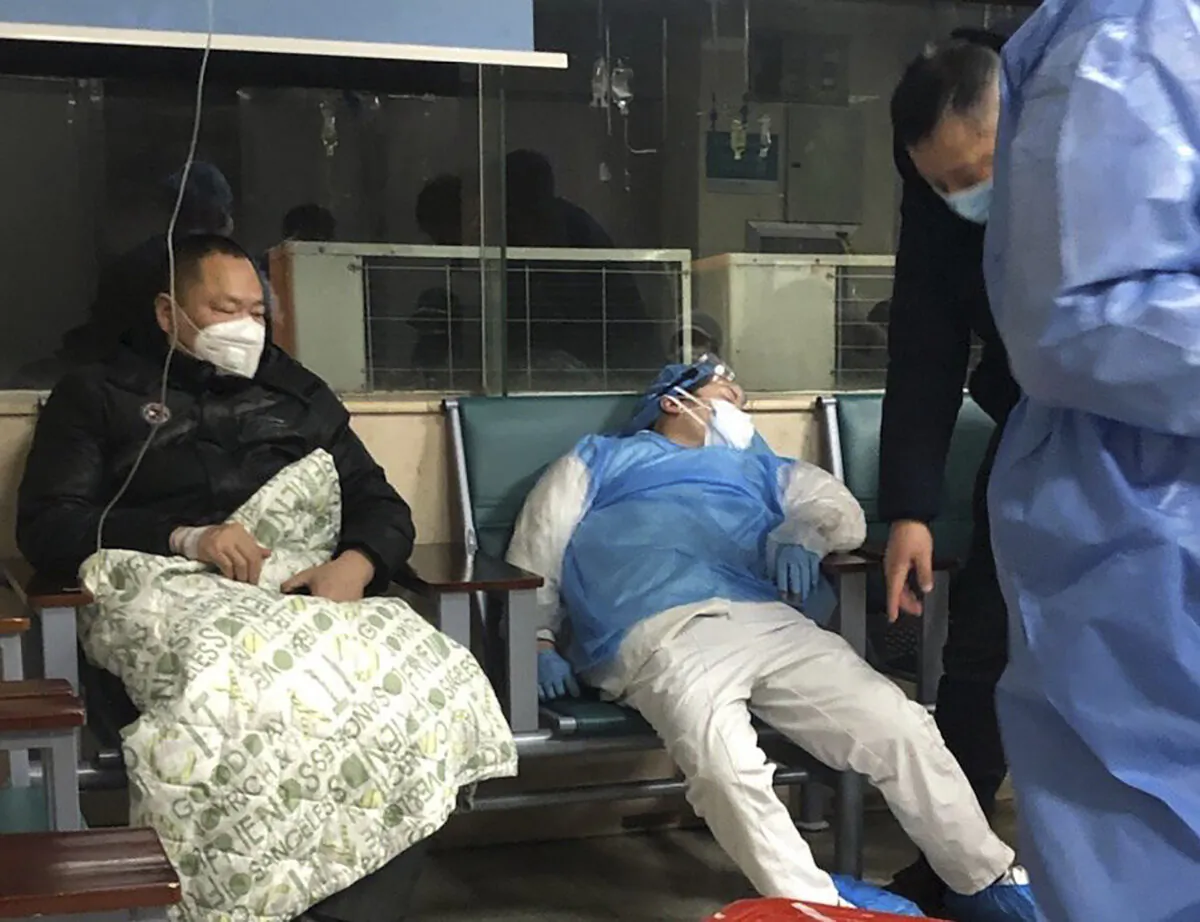 A medical worker (R) rests in a chair next to a patient at a hospital in Wuhan, Hubei Province, China, on Jan. 23, 2020. (AP Photo)