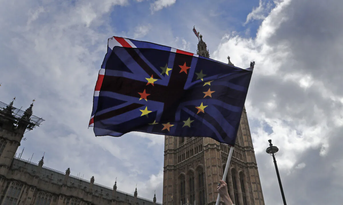 A pro-EU protester waves flags opposite the Houses of Parliament in London on April 4, 2019. (Frank Augstein/AP Photo)