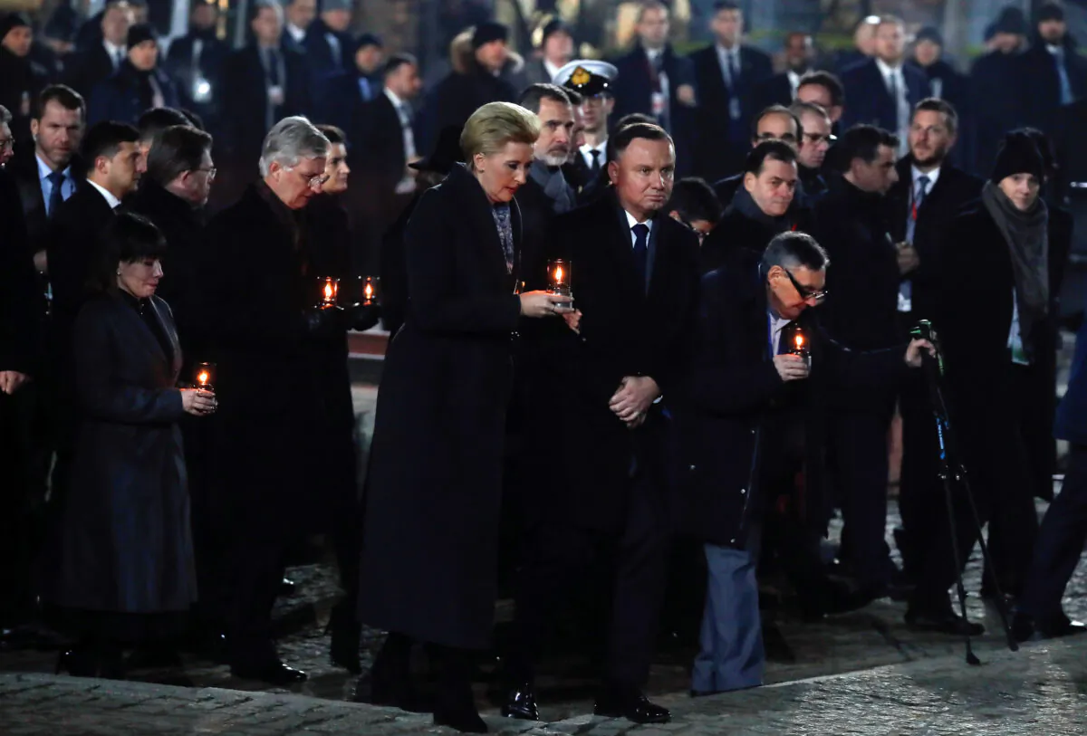 Poland's President Andrzej Duda and his wife Agata Kornhauser-Duda, Holocaust survivor Marian Turski, King Philippe of Belgium, King Felipe of Spain walk with candles to light them at the Monument to the Victims at the former Nazi German concentration and extermination camp Auschwitz II-Birkenau, during ceremonies marking the 75th anniversary of the liberation of the camp and International Holocaust Victims Remembrance Day, in Brzezinka near Oswiecim, Poland, on Jan. 27, 2020. (Aleksandra Szmigiel/Reuters)