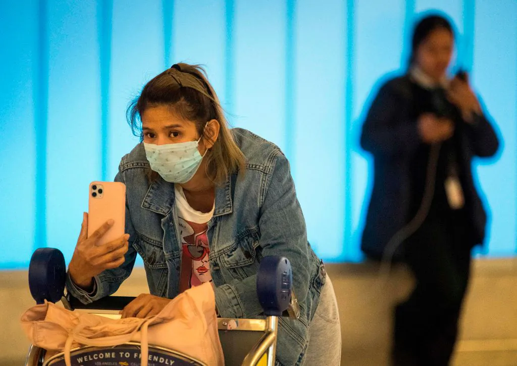 Passengers wear masks to protect against the spread of the Coronavirus as they arrive at the Los Angeles International Airport, California, on Jan. 22, 2020. (Mark Ralston/AFP via Getty Images)