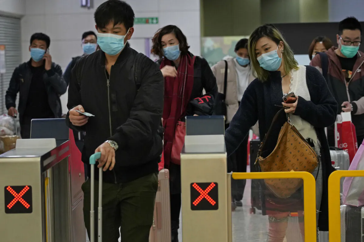 Passengers wearing protective face masks arrive at the high speed train station in Hong Kong on Jan. 28, 2020. Hong Kong's leader has announced that all rail links to mainland China will be cut starting Friday as fears grow about the spread of a new virus. (Vincent Yu/AP Photo)
