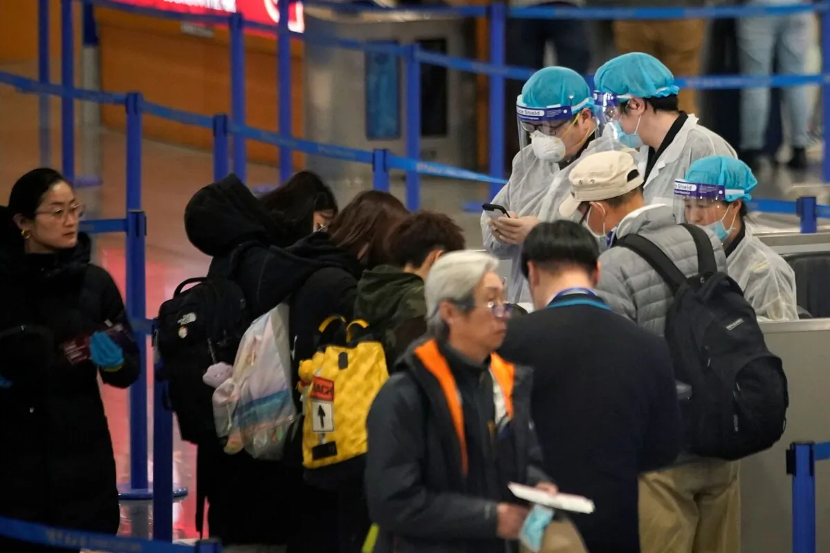 Medical officials are seen as passengers leave at the Pudong International Airport in Shanghai, China, on Jan. 27, 2020. (Aly Song/Reuters)