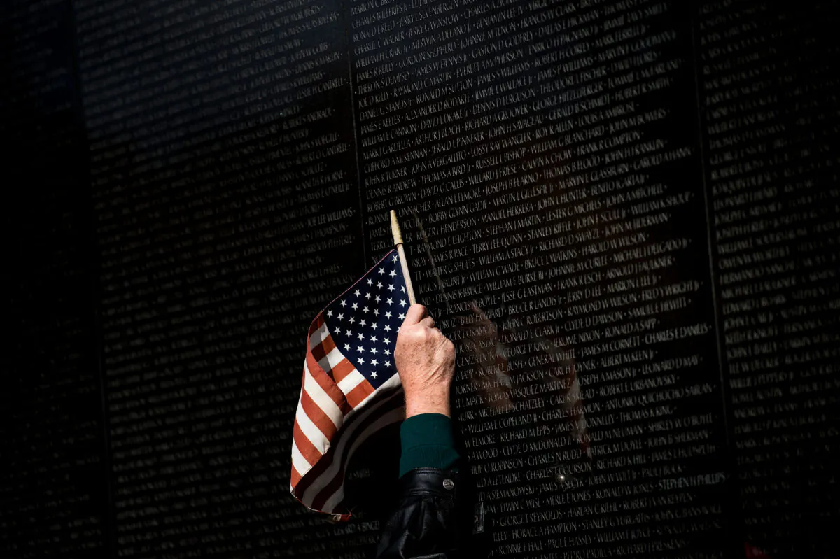 A man points to a name while visiting the Vietnam War Memorial on Veterans Day in Washington on Nov. 10, 2017.  Brendan Smialowski/AFP via Getty Images