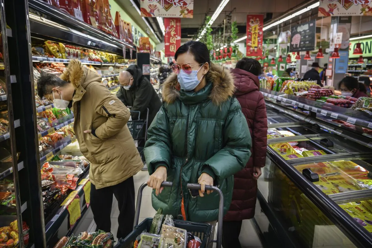 A Chinese woman wears a protective mask and sunglasses as she shops for groceries at a supermarket in Beijing on Jan. 28, 2020. (Kevin Frayer/Getty Images)