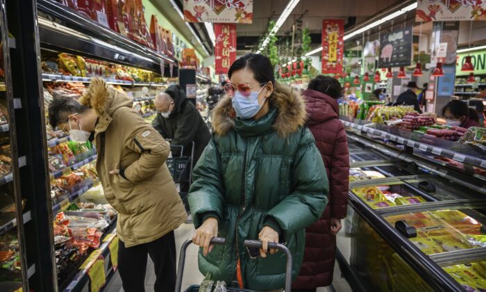 A Chinese woman wears a protective mask and sunglasses as she shops for groceries at a supermarket in Beijing on Jan. 28, 2020. (Kevin Frayer/Getty Images)