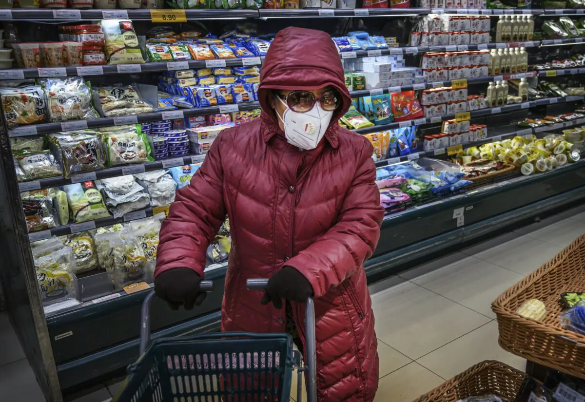 A Chinese woman wears a protective mask and sunglasses as she shops for groceries at a supermarket in Beijing, China on Jan. 28, 2020. (Kevin Frayer/Getty Images)