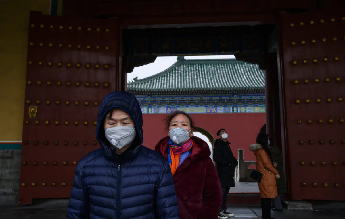 Chinese visitors wear protective masks as they tour the Temple of Heaven, which remained open during the Chinese New Year and Spring Festival holiday in Beijing, China, on Jan. 27, 2020. (Kevin Frayer/Getty Images)