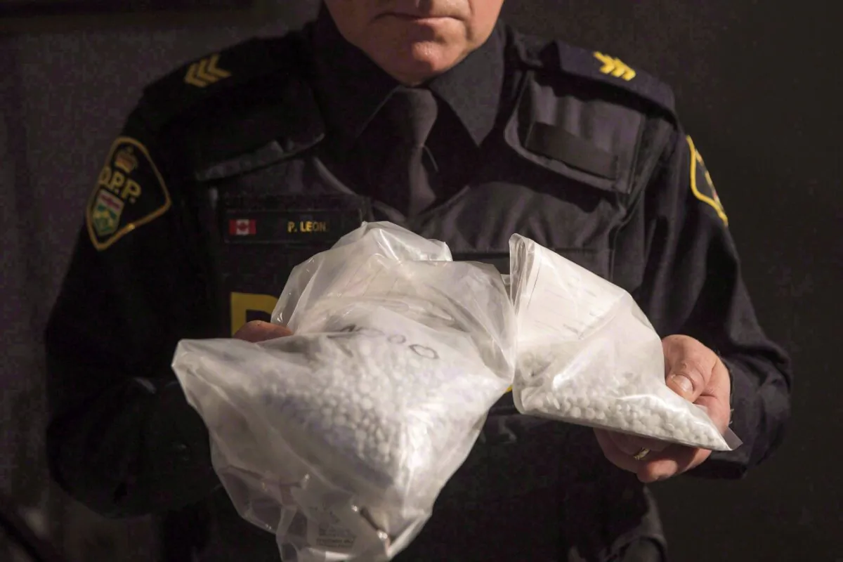 An Ontario Provincial Police officer displays bags containing fentanyl during a news conference in Vaughan, Ont., Canada, on Feb. 23, 2017. (The Canadian Press/Chris Young)