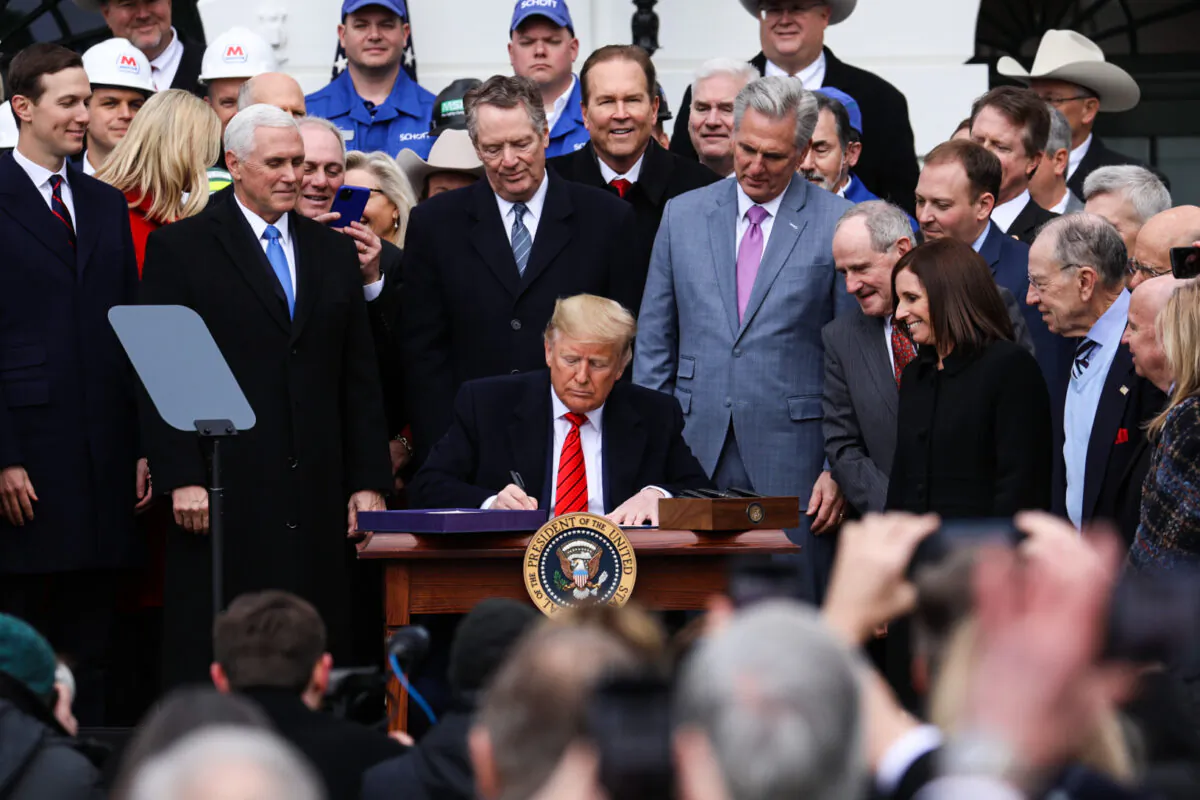 President Donald Trump signs the United States–Mexico–Canada Agreement, known as USMCA, during a ceremony on the South Lawn of the White House on Jan. 29, 2020. (Charlotte Cuthbertson/The Epoch Times)