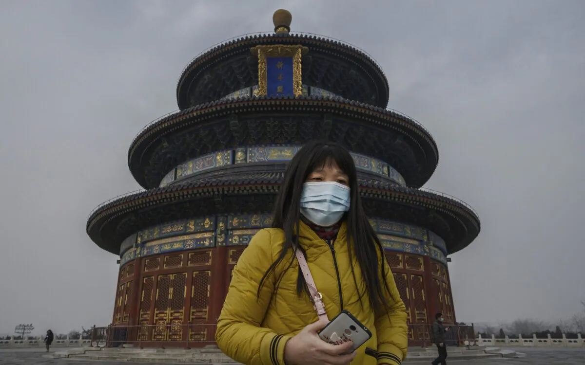 A Chinese visitor wears a protective mask as she tours the grounds of the Temple of Heaven in Beijing, on Jan. 27, 2020. (Kevin Frayer/Getty Images)