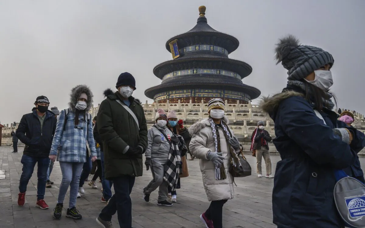 Visitors wear protective masks as they tour the grounds of the Temple of Heaven in Beijing on Jan. 27, 2020. (Kevin Frayer/Getty Images)