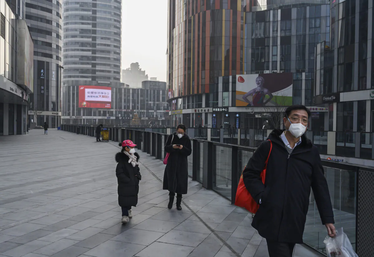 A Chinese family wears protective masks as they walk in an empty shopping area that would usually be busy during the Chinese New Year and Spring Festival holiday in Beijing, China on Jan. 28, 2020. (Kevin Frayer/Getty Images)