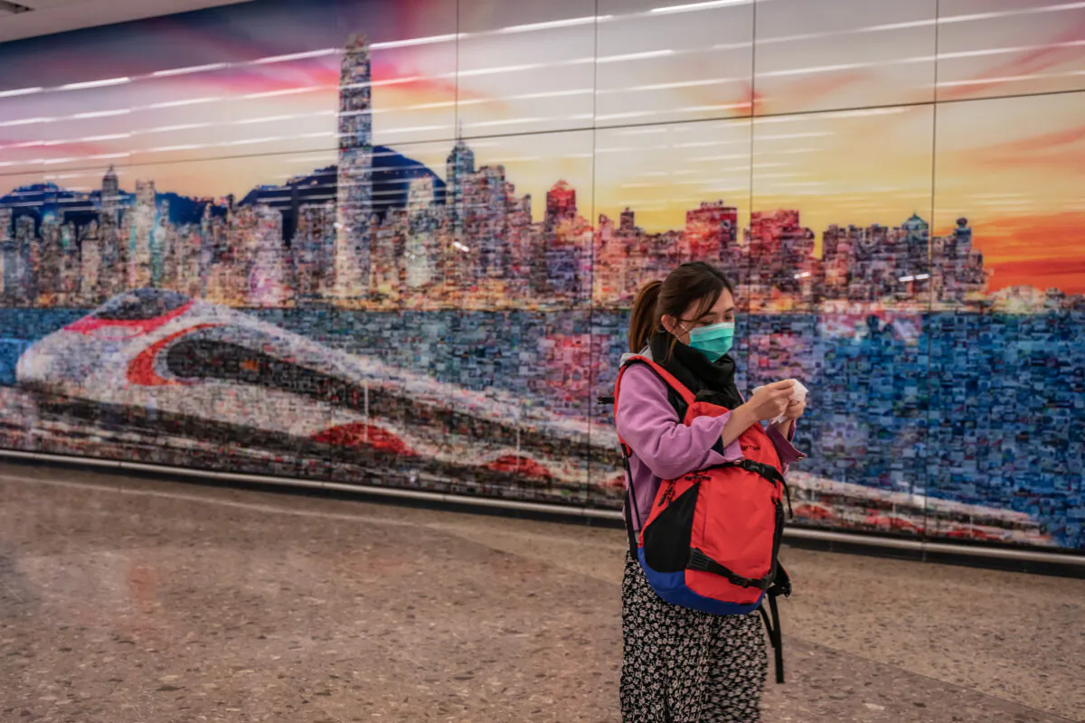 A woman wearing a protective mask exits the arrival hall at Hong Kong High Speed Rail Station on Jan. 29, 2020. (Anthony Kwan/Getty Images)